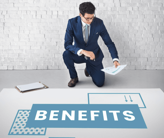 A Clinical Counsellor in a suit kneeling on the floor with a piece of paper with the word benefits.