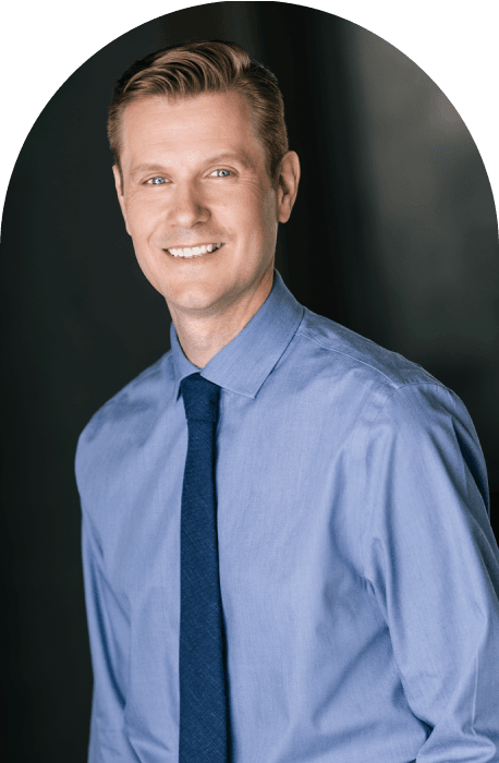 A smiling clinical counselor in a blue shirt and tie.