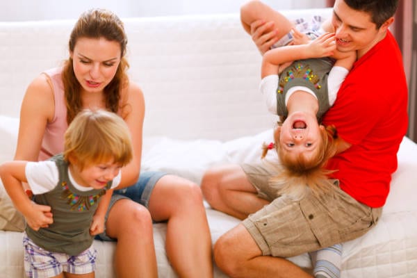 A family seeking divorce counseling sitting on a couch with two children.