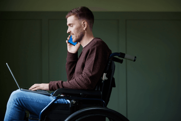 A man in a wheelchair using a phone to discuss mental health.