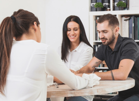 A Surrey counselor discusses with a couple at a table.