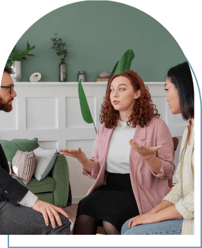 Three people engaging in a therapeutic conversation, addressing mental health concerns, while seated in a circle.