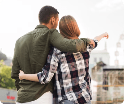 A couple embracing in front of a ferris wheel portrays intimacy in the context of couples and family therapy.