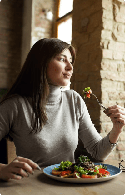 A woman practicing self-care by consuming a nutritious salad.