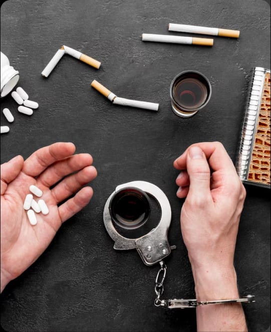 A hand holding a cup of coffee and a hand with a handcuff, symbolizing the complex relationship between mental health and confinement.