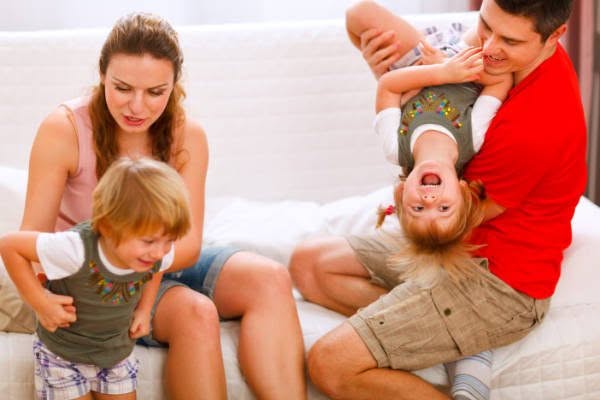 A family seeking divorce counseling sitting on a couch with two children.